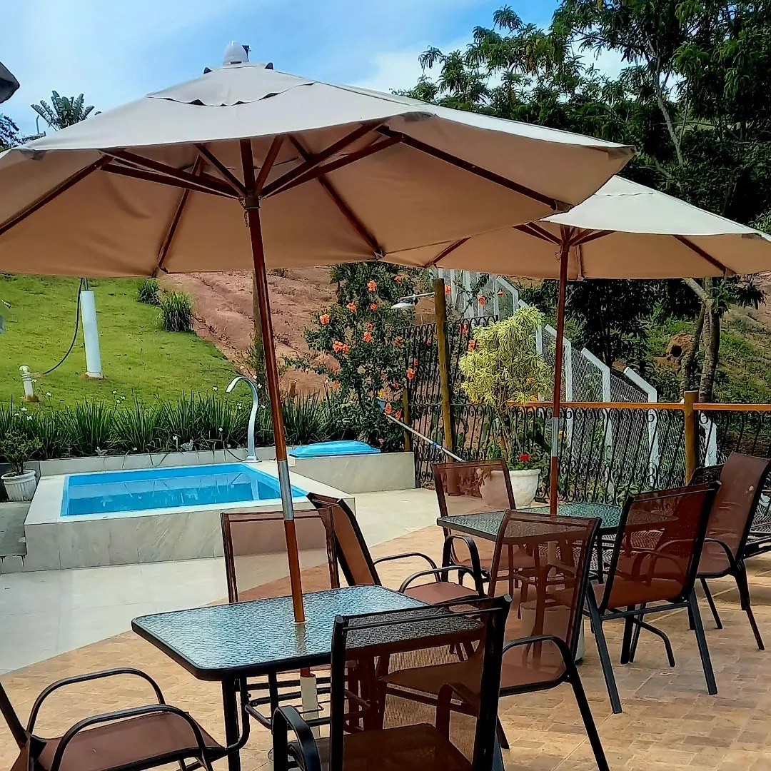 Piscina com área de descanso e guarda-sóis