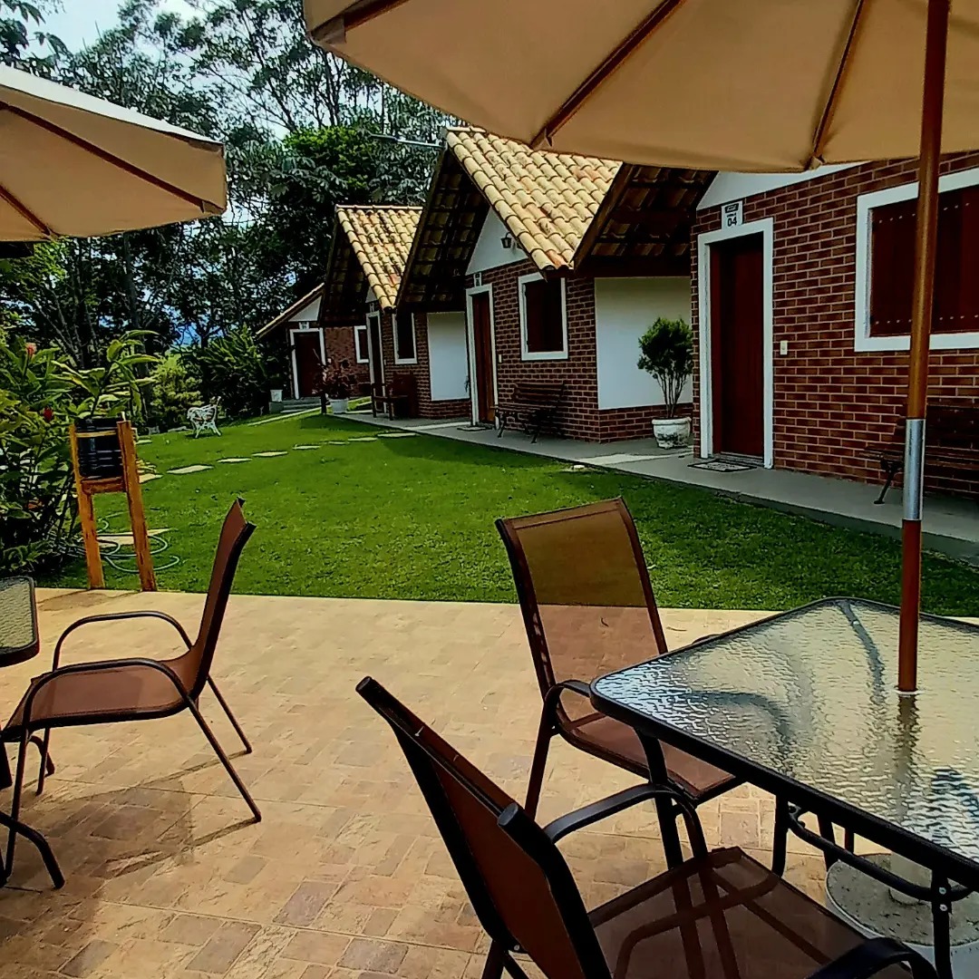 Chalés vistos do jardim com mesas e guarda-sóis