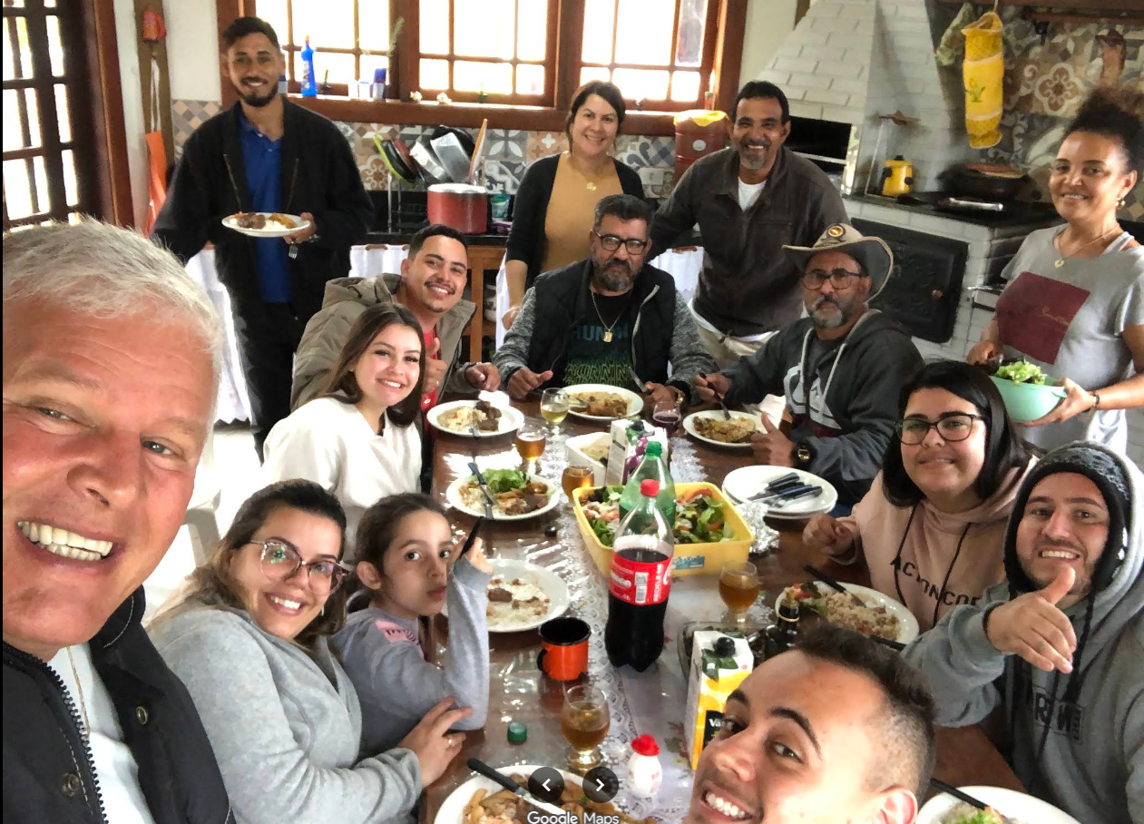 Família e amigos reunidos em almoço na cozinha do Recanto Feliz