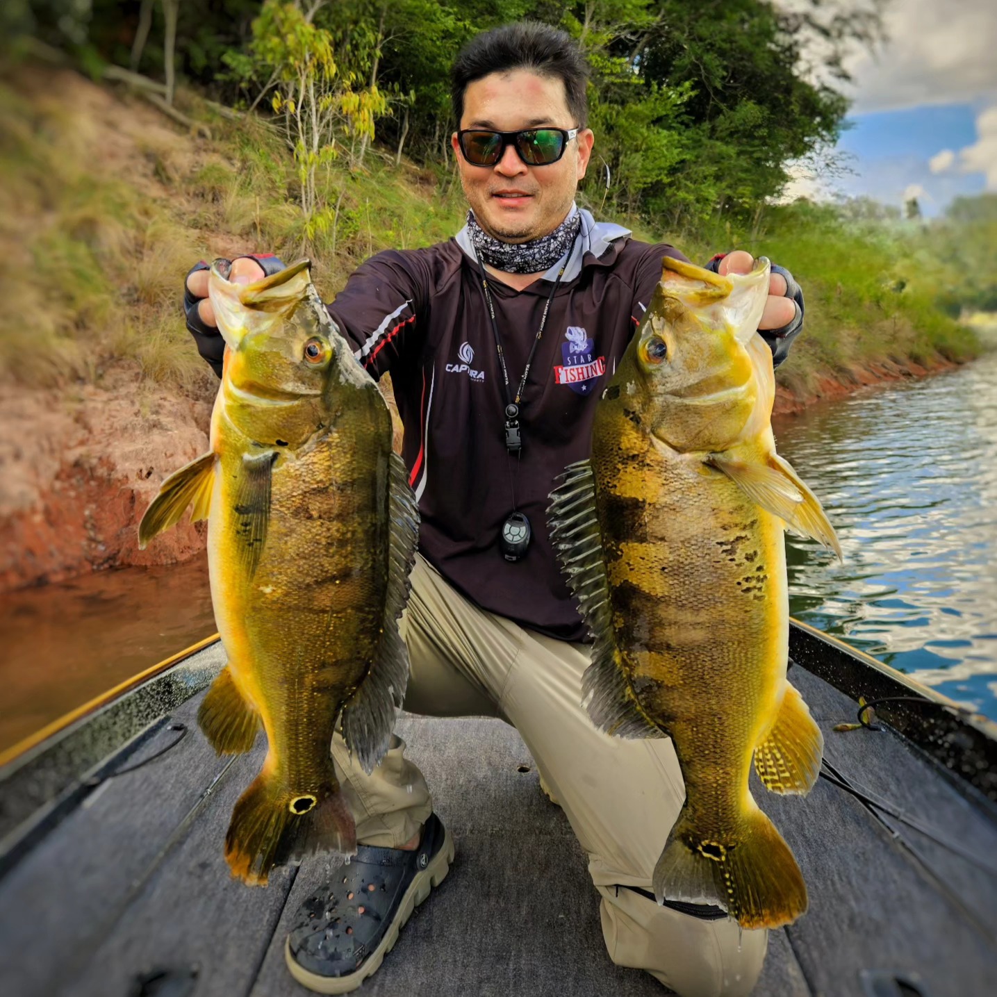 Pescador exibindo dois tucunarés